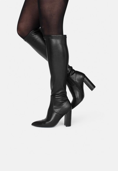 Model präsentiert die schwarzen Lauren Stiefel mit hohem Absatz, modischer Look.