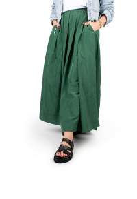 Close-up of model wearing a green skirt and black Scottie sandals made of faux leather.