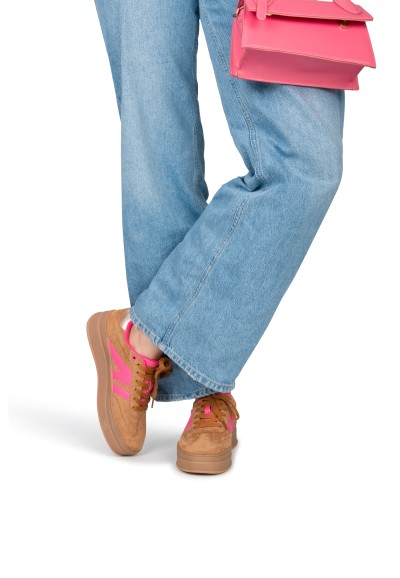 Model draagt camel-roze NOË sneaker met jeans