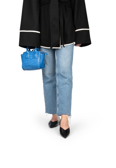 Model draagt FELINE ballerina – zwarte platte schoen gestyled met jeans en blazer