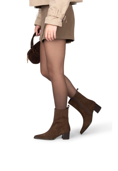 Model draagt bruine Febe enkellaarzen van PS Poelman met rok en tas.