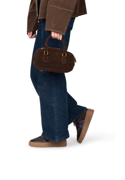 Vrouw met jeans en bruine tas draagt ANEMONE sneakers