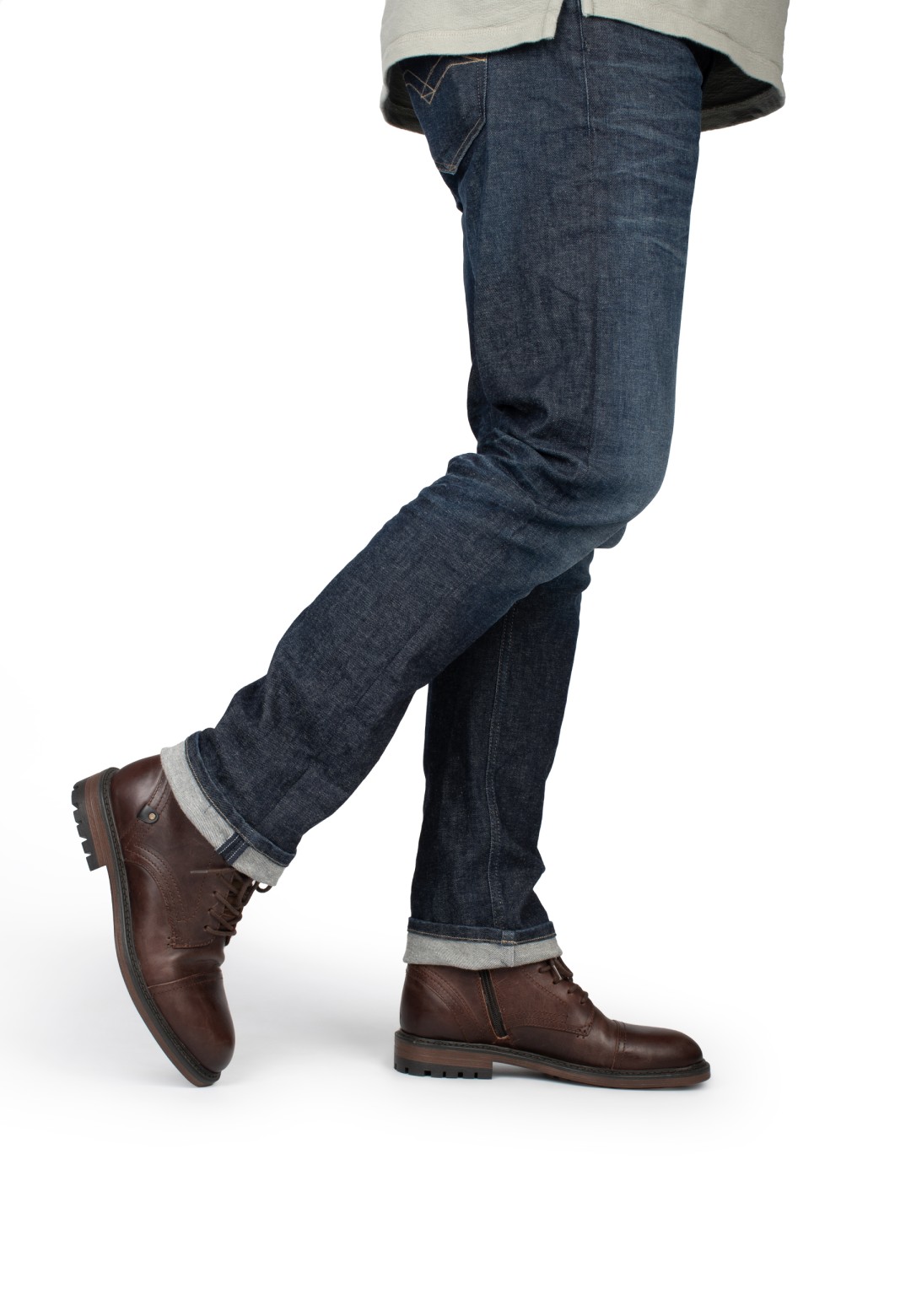 Model trägt dunkelblaue Jeans mit braunen Leder-Hombre Schuhen von PS Poelman.