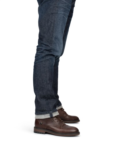 Zijaanzicht van model met leren Hombre veterboots, casual mannelijke look.