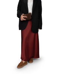 Vrouw draagt PS Poelman suède loafers met bordeauxrode rok en zwarte blazer