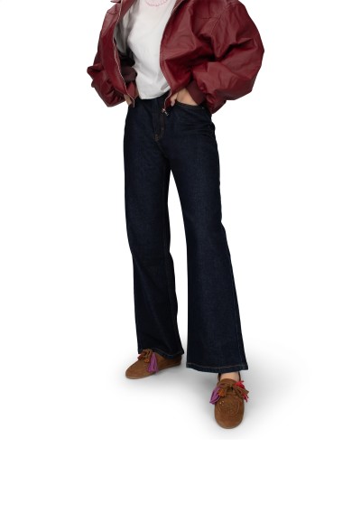 Model draagt donkerblauwe jeans met bruine Vita loafers van PS Poelman.