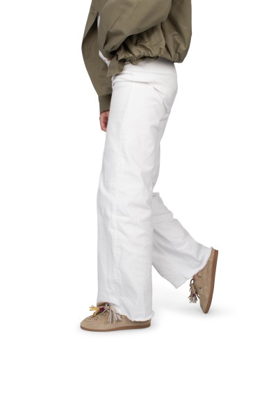 Side view of model wearing white trousers and beige Vita loafers, casual look.