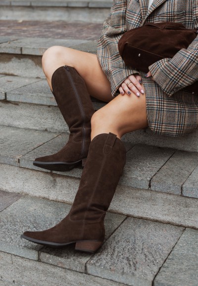 Close-up of model wearing the tall brown boots, showing texture and fit.