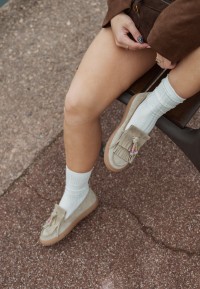 Vrouw draagt PS Poelman loafers met witte sokken, close-up van voeten