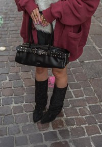 Model styling LOIS boots with black handbag, top-down outfit view