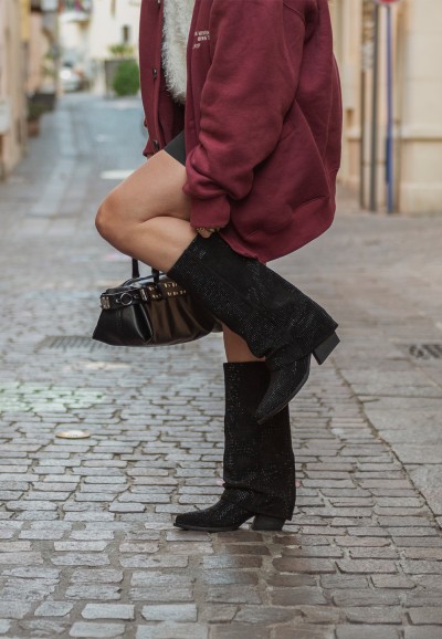 Model wearing LOIS boots on the street with raised leg – stylish and confident
