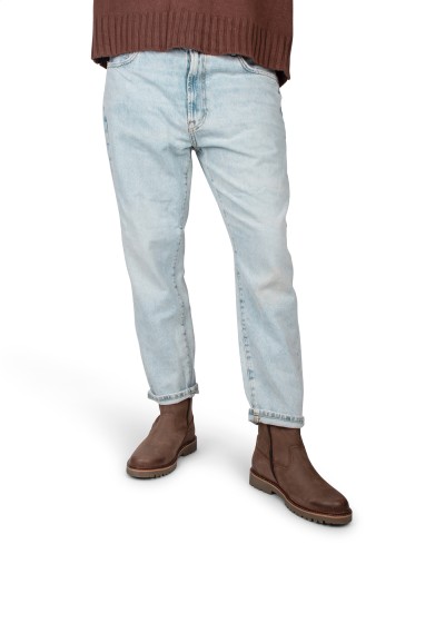 Model draagt lichtblauwe jeans met bruine Toni enkellaarzen van PS Poelman.