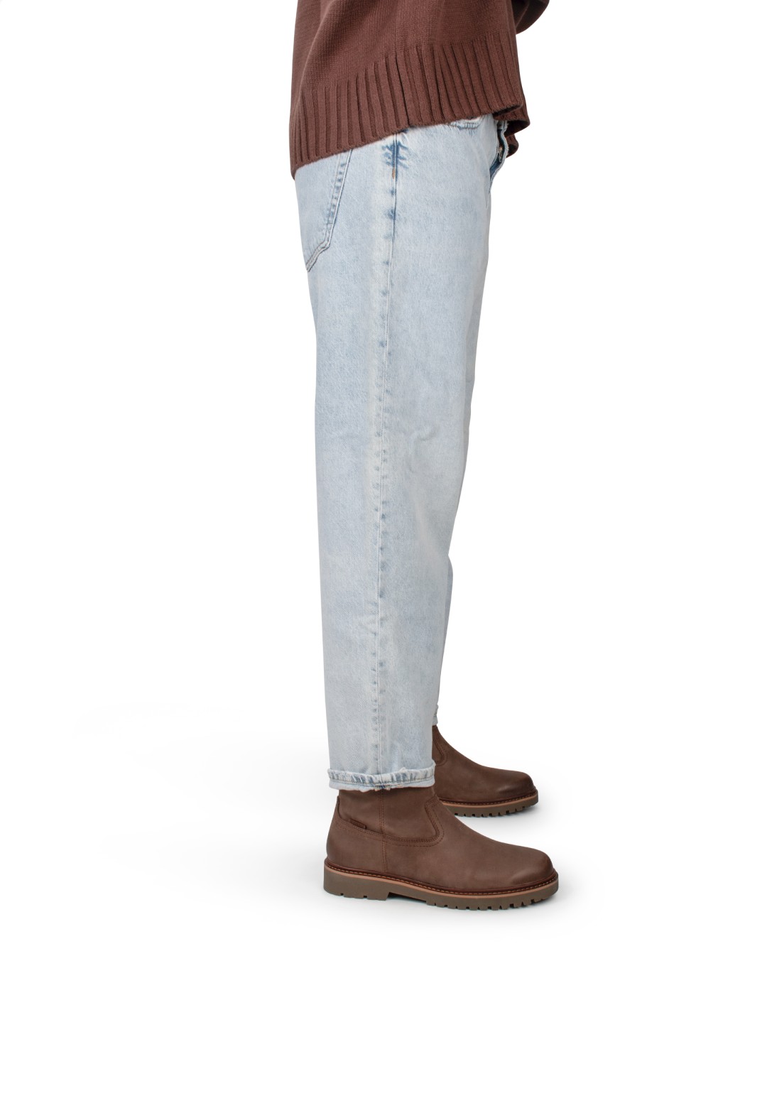 Zijaanzicht van model met jeans en Toni enkellaarzen, casual look.