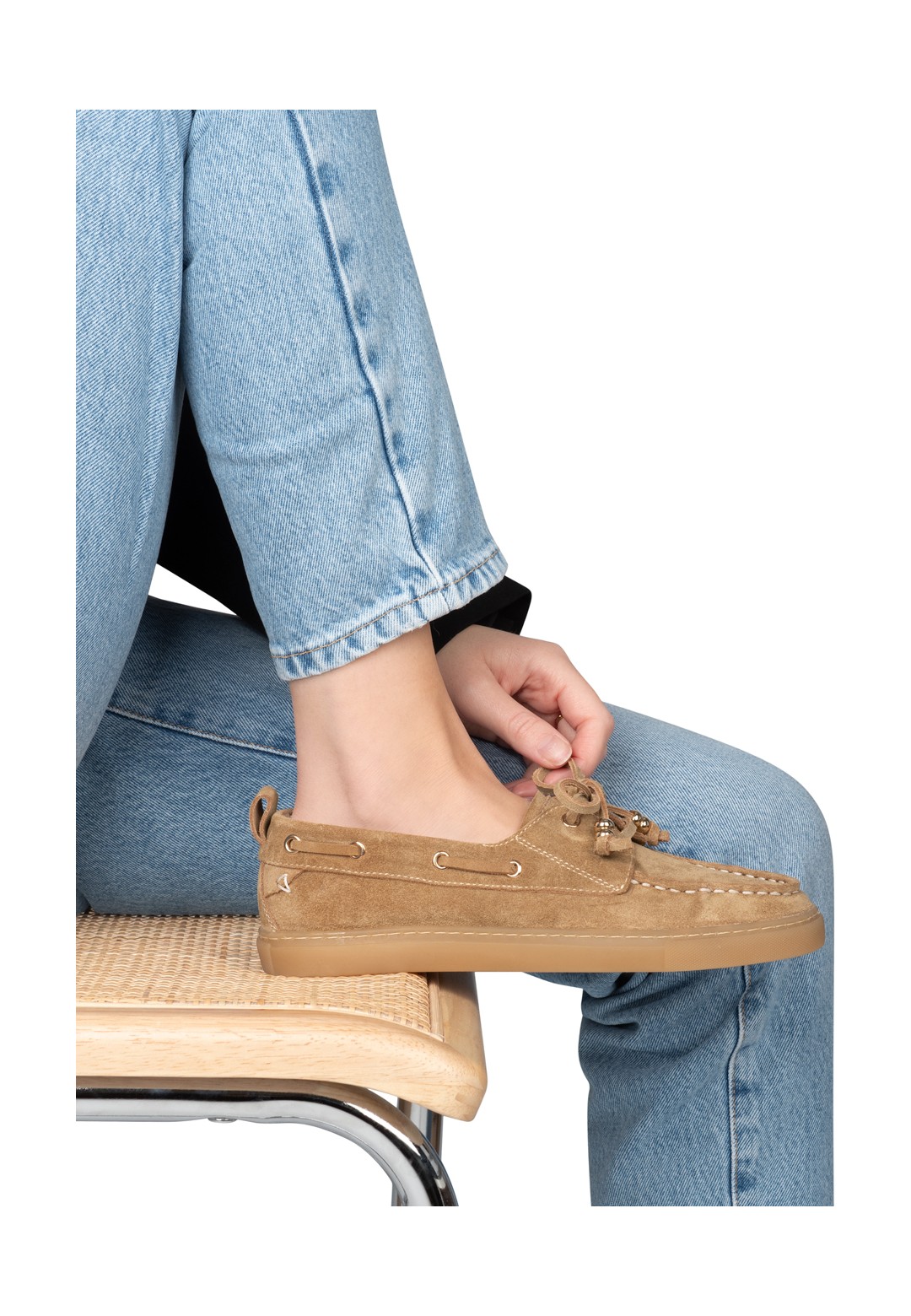 Beige suède loafer gedragen door vrouw, zittend met jeans – zijaanzicht