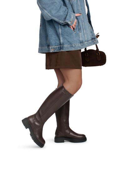 Model draagt FAY laarzen – hoge imitatie leren laarzen gestyled met denim jas en rok