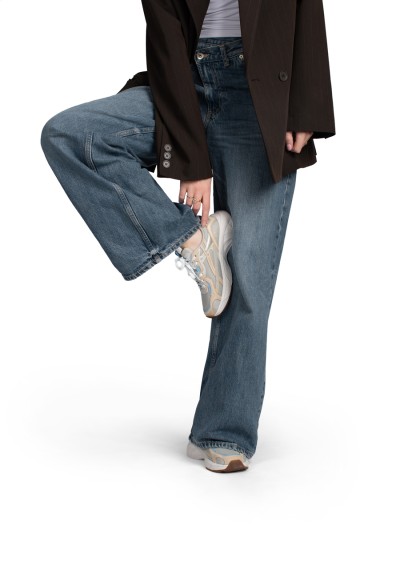 HARPER sneakers – gedragen met jeans, model tilt voet omhoog