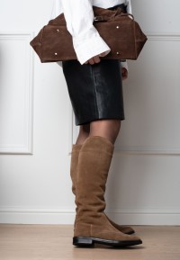 Model trägt Isabella kniehohe Stiefel aus cognacfarbenem Veloursleder, Seitenansicht knapp unterhalb des Knies.