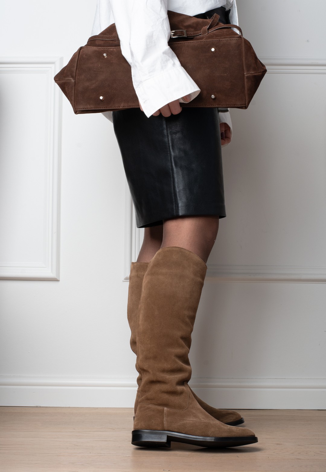 Model trägt Isabella kniehohe Stiefel aus cognacfarbenem Veloursleder, Seitenansicht knapp unterhalb des Knies.