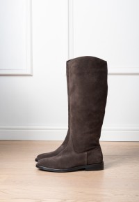 Isabella suede knee-high boot in dark brown, worn by model indoors, side view.