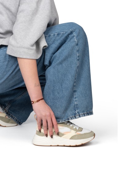 Detailshot van CARO sneaker tijdens dragen met denim look