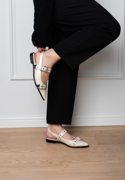 Close-up van JULIA slingbacks aan de voet bij witte muur