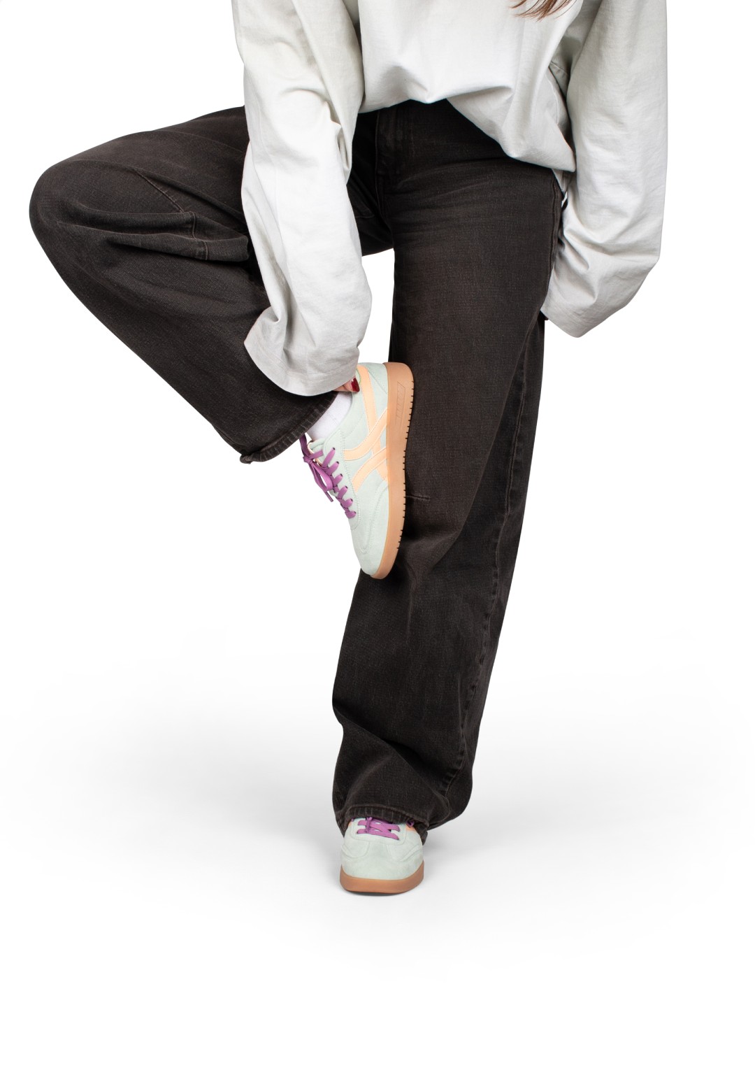 MEGAN sneaker gedragen, been opgetild in sportieve pose