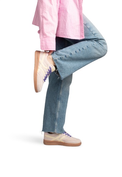 MEGAN sneaker gedragen met jeans, been speels omhoog