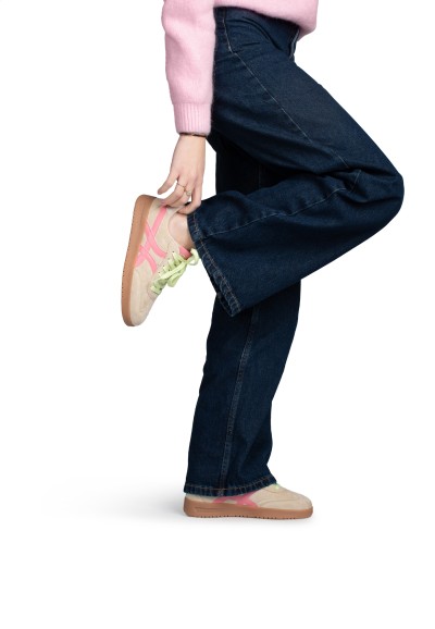 MEGAN sneaker gedragen, been opgetild in sportieve pose