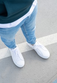 Close-up van NERO sneakers gedragen met jeans