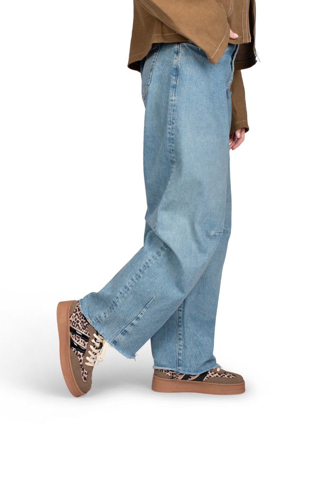 Model loopt op LILLY sneakers van POSH by Poelman met wijde jeans, zijaanzicht