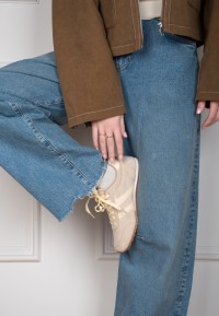 Close-up of the MAXINE sneaker worn by a model in denim jeans