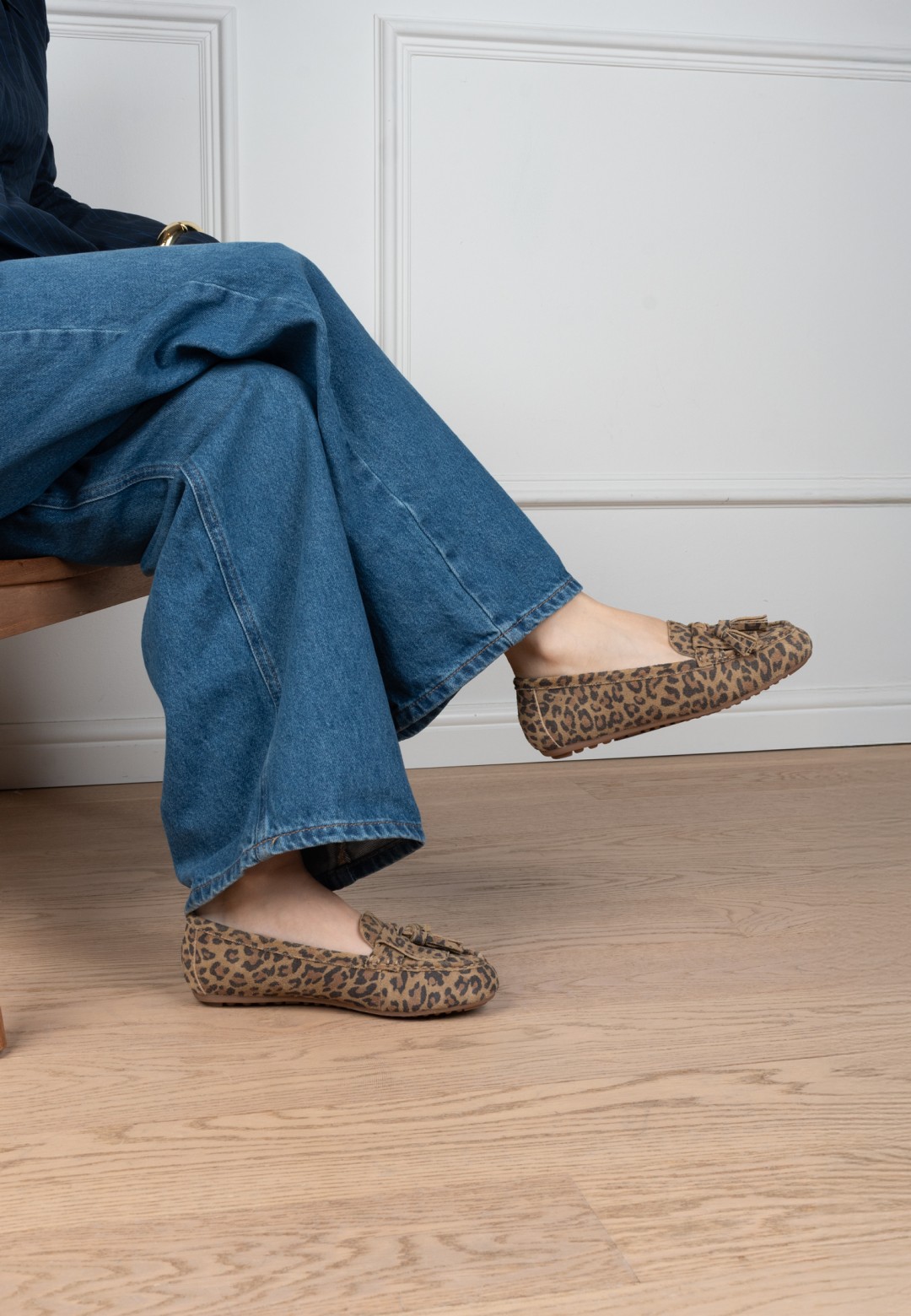 Getragene TAYA Slipper mit Leopardenmuster zu Schlagjeans – sitzende Pose