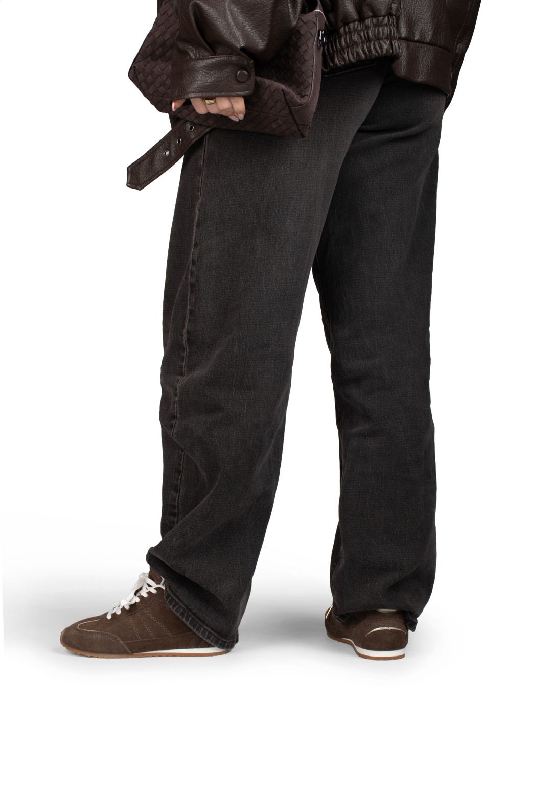 Standing model in dark jeans with brown sneakers visible from the side