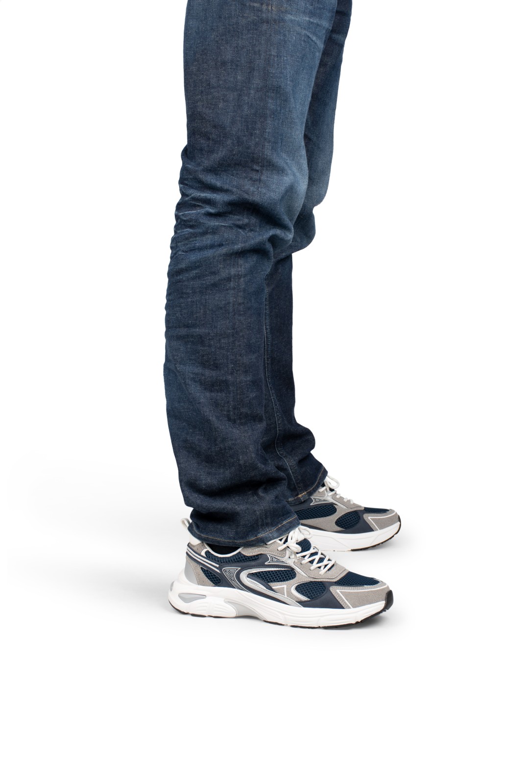 Standing model wearing grey-blue sneakers with dark jeans