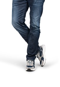 Model walking wearing grey-blue sneakers with dark jeans