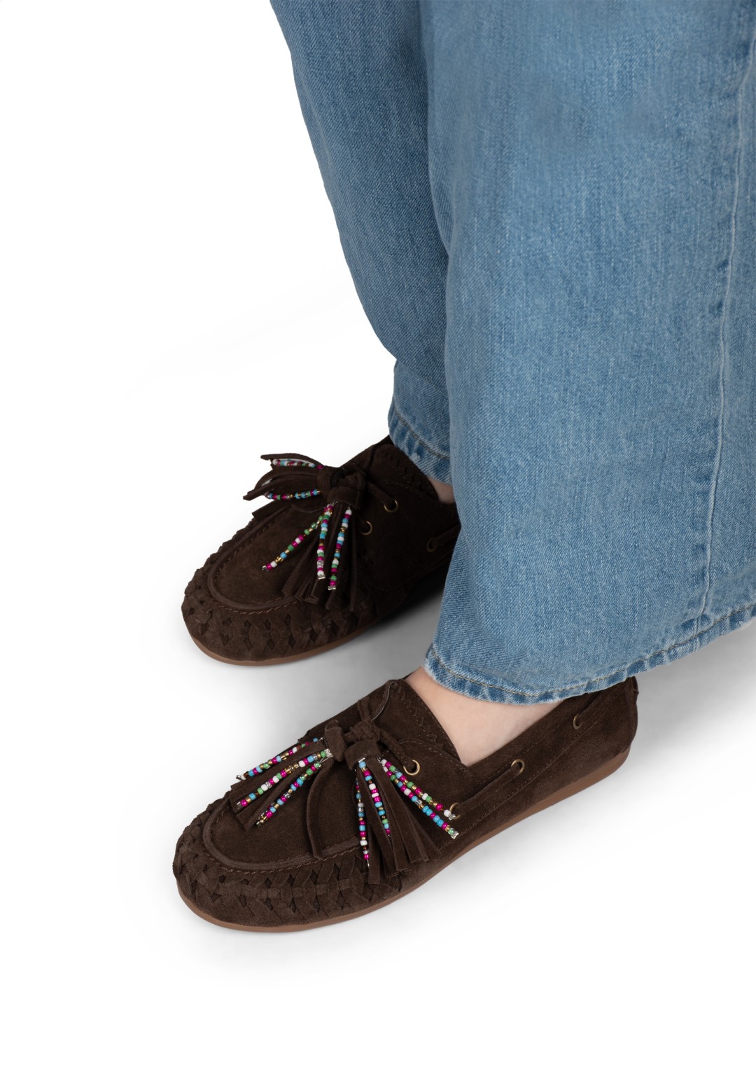 Brown fringe loafers worn with jeans