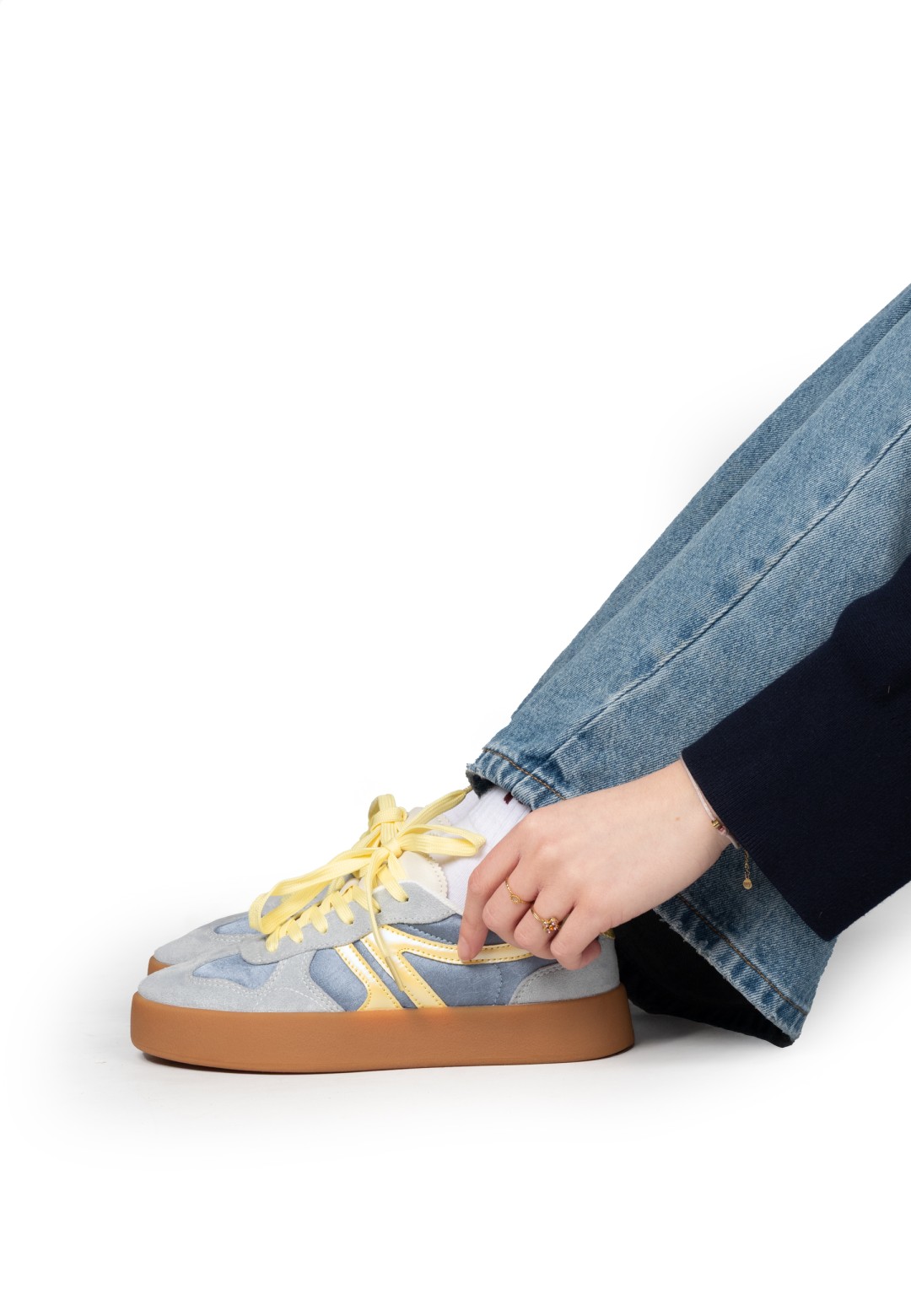Getragener Sneaker zu Jeans, Fuß auf dem Boden