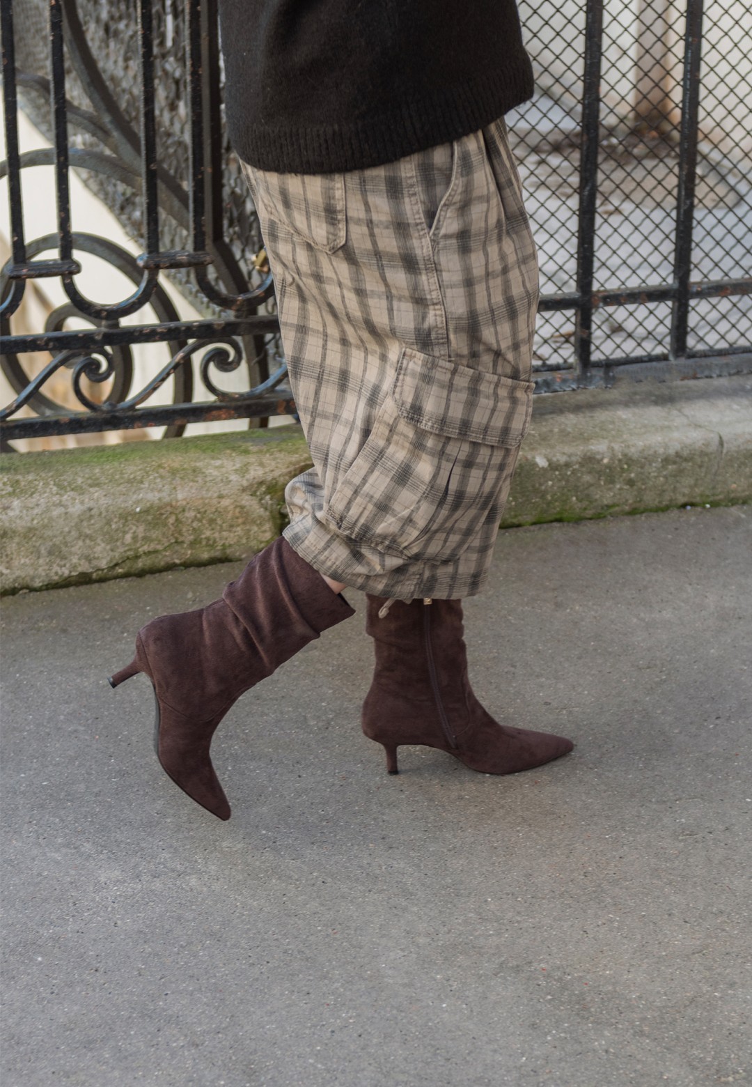 Model walking in the trendy ELLY boots by POSH by Poelman, combined with checkered trousers.
