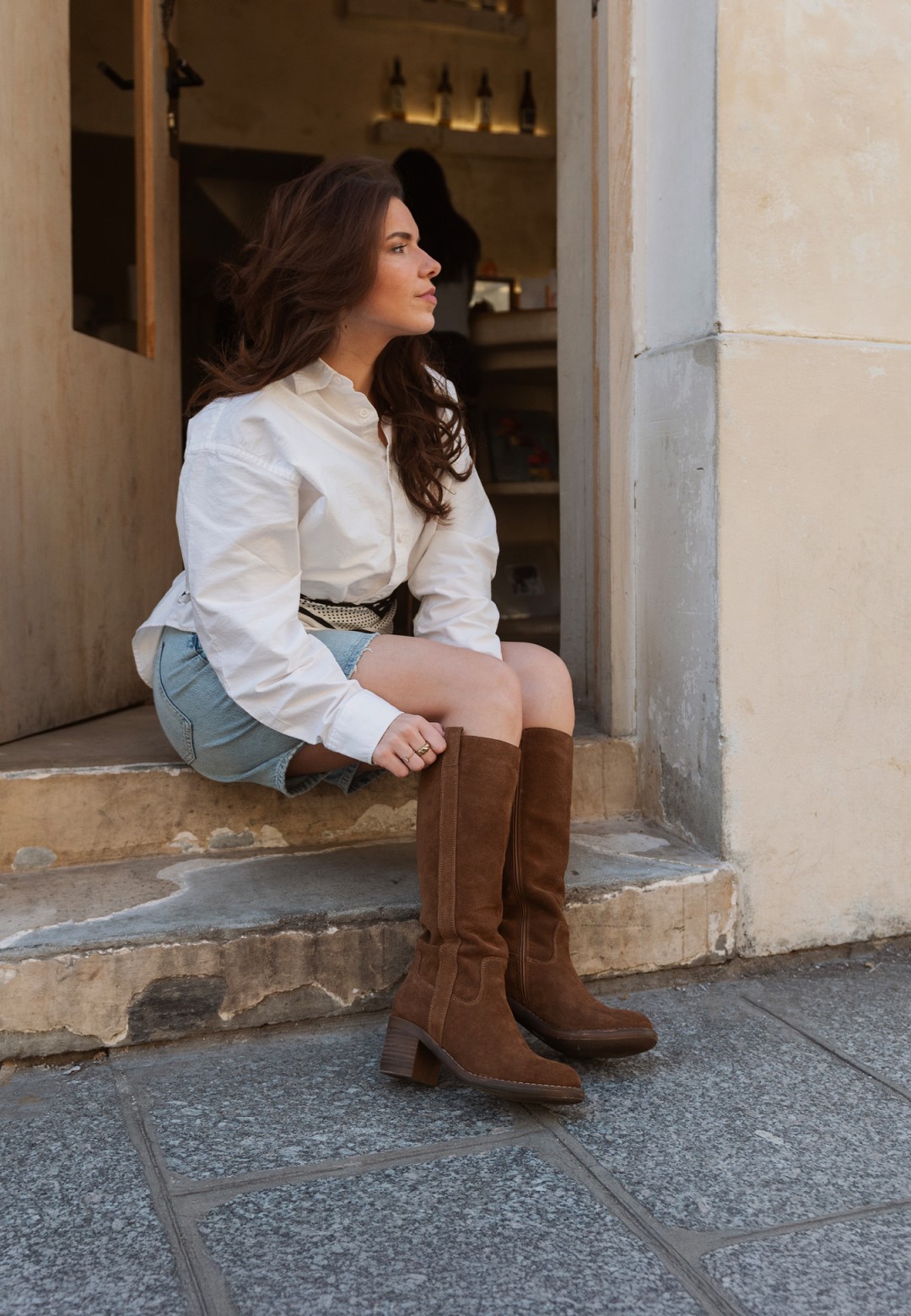 PS Poelman SAS Damen kniehohe Stiefel aus cognac Wildleder – Lifestylebild auf Treppe sitzend