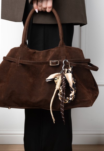 Bag-Charm von POSH by Poelman mit Leopardenmuster und goldenen Details an einer braunen Wildledertasche.