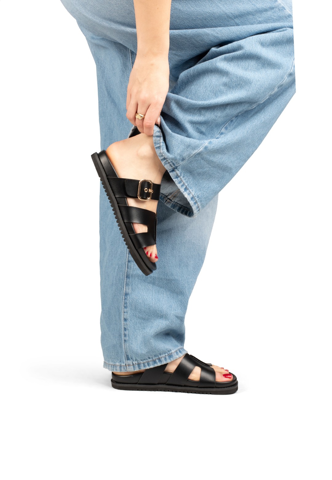 Model wearing POSH by Poelman Livia black sandals with denim jeans – side view