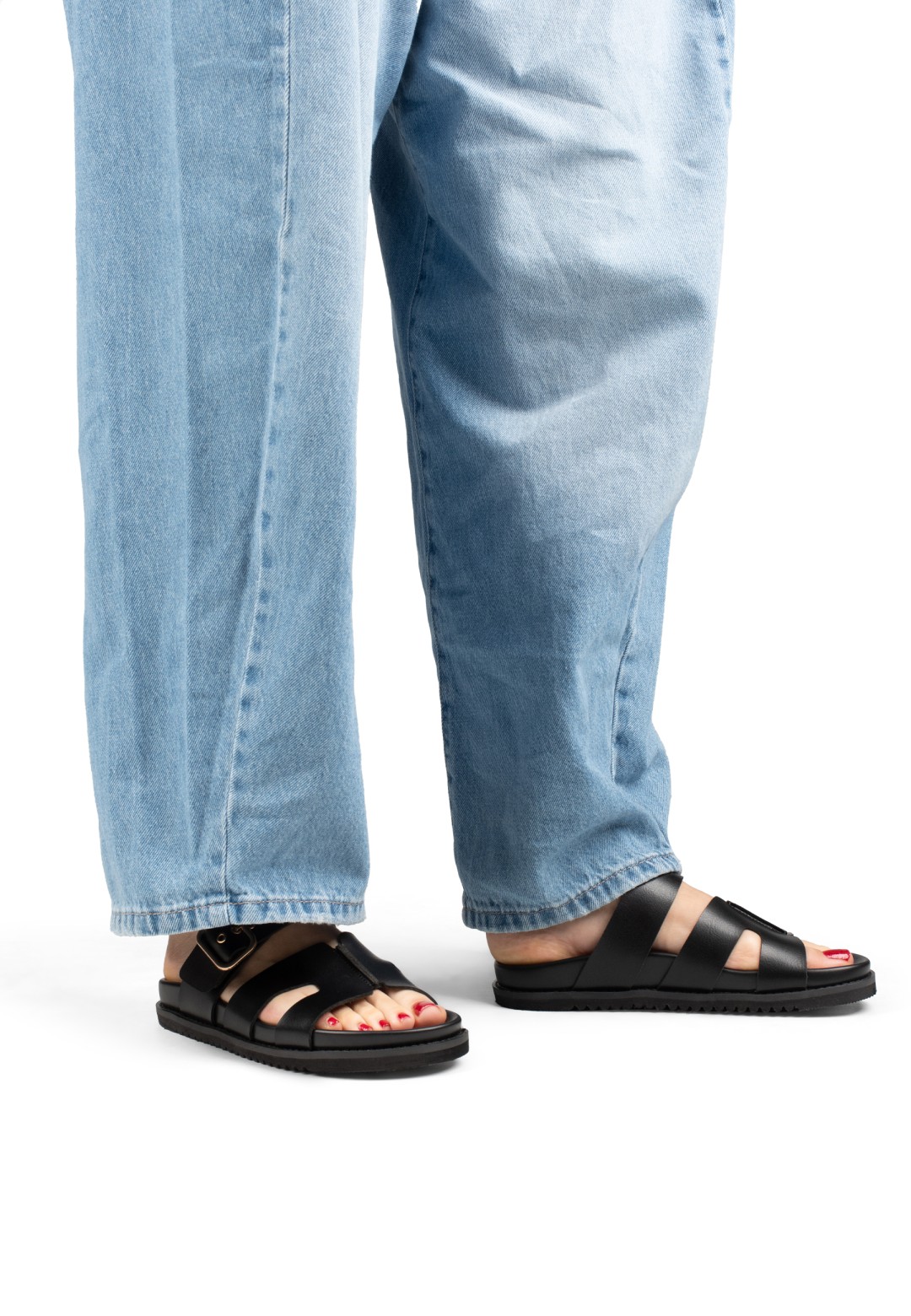 Model wearing POSH by Poelman Livia black sandals with denim jeans – close-up