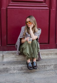 Model wearing POSH by Poelman Bella dark red loafers with green trousers and sunglasses – street style