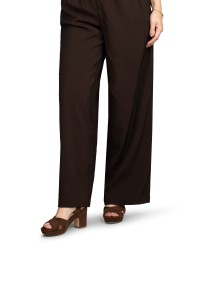 Model draagt bruine POSH by Poelman sandalen met hak en wijde broek