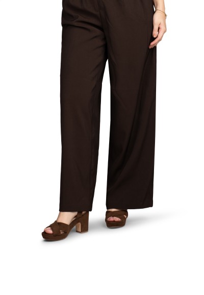 Model wearing brown POSH by Poelman heeled sandals with wide leg pants
