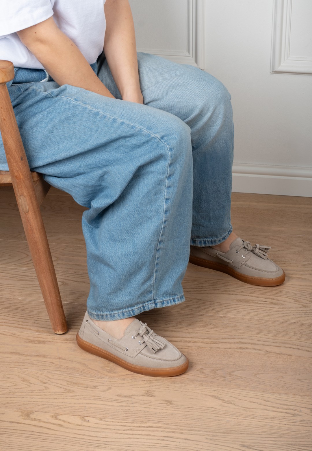 Model trägt PS Poelman Ilse sand Loafer mit Jeans sitzend – Innenaufnahme