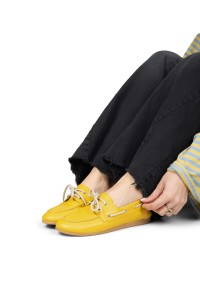 Model zieht PS Poelman Callie gelbe Loafer an mit schwarzer Hose – Detailaufnahme