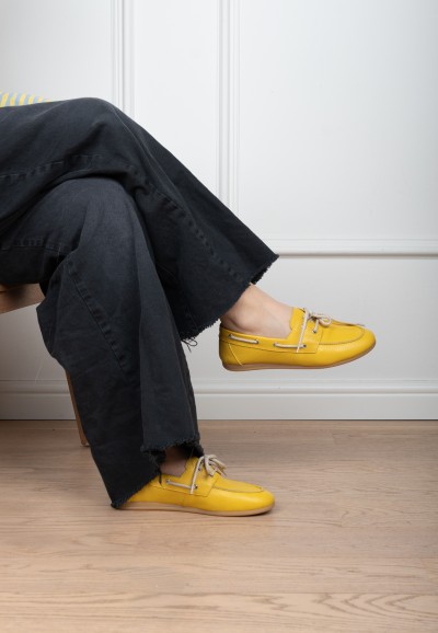 Model wearing PS Poelman Callie yellow loafers with black trousers sitting – indoor