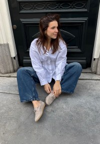 Model trägt PS Poelman Callie beige Loafer sitzend draußen – Lifestyle