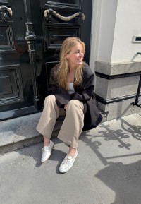 Model trägt PS Poelman Callie weiße Loafer sitzend draußen – Lifestyle